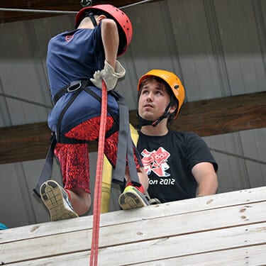 Activity Period Adventure At Camp - Camper going down rappel wall on ropes course - Cub Creek Science and Animal Camp