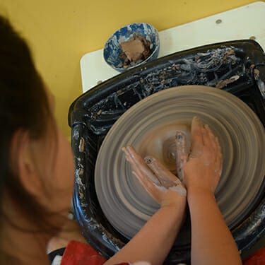 Activity Period Arts And Crafts At Camp - Camper in pottery studio - pottery wheel - Cub Creek Science and Animal Camp