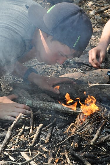 Adventure At Camp - Camper starting fire in survival skills - Cub Creek Science Camp