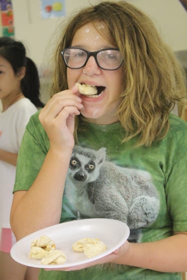 Arts & Crafts At Camp - Camper eating pretzels from culinary - Cub Creek Science and Animal Camp