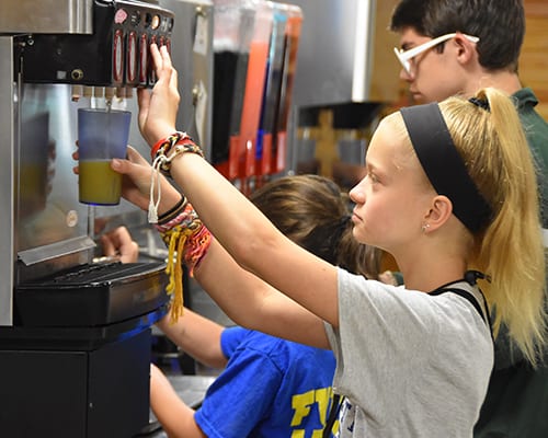 Camp Meals - camper getting drinks at dispenser - Cub Creek Science and Animal Camp